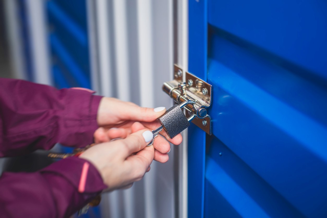Woman securing a storage unit with a lock and key